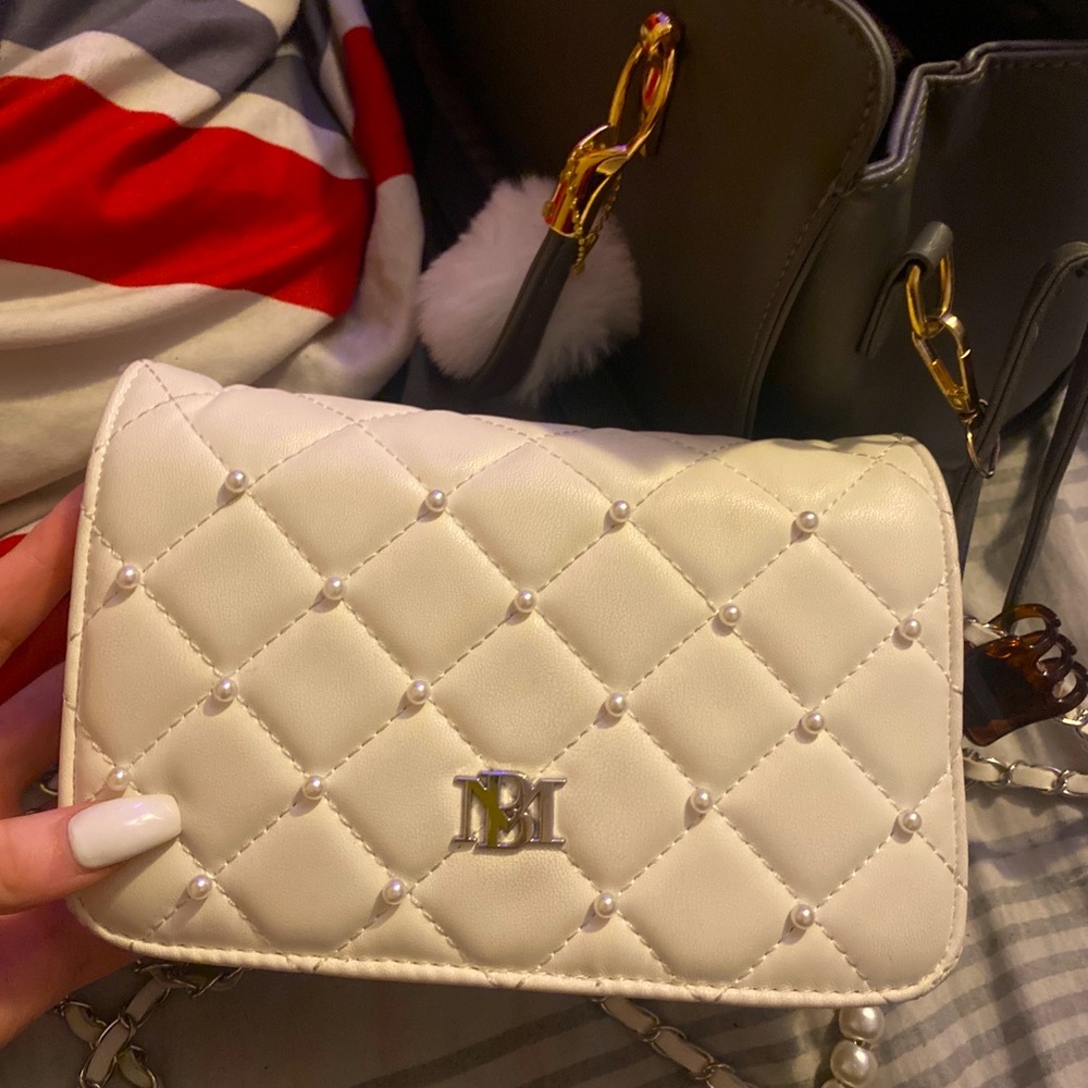 small white purse, fits over shoulder, stores tons of stuff! cards, money, phone